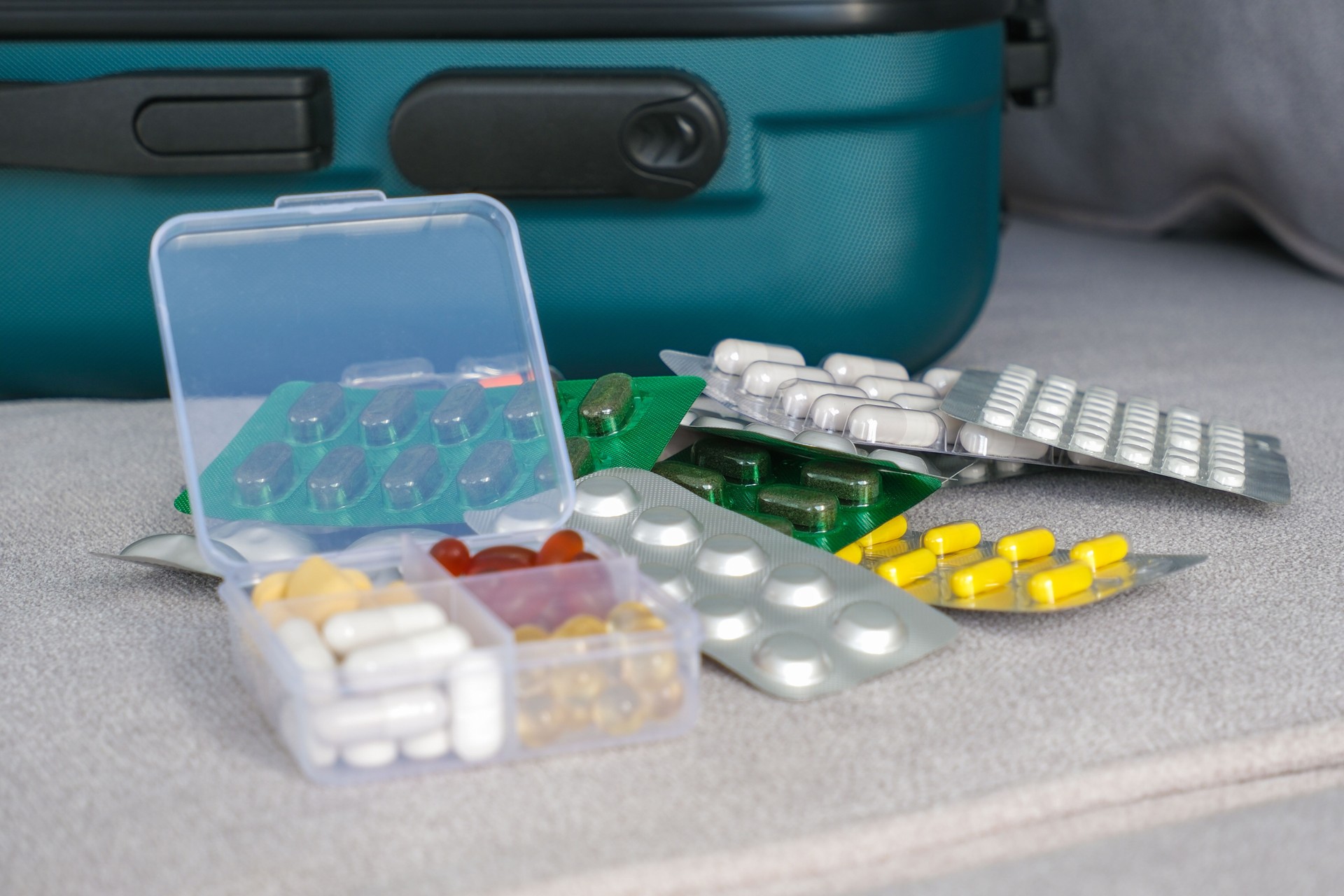 Pills in a suitcase. Concept of medication required in journey
